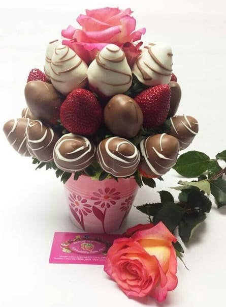 Imagen de Chocoflor Descripcion: Frutillas bañadas en chocolate en una taza con 2 rosas