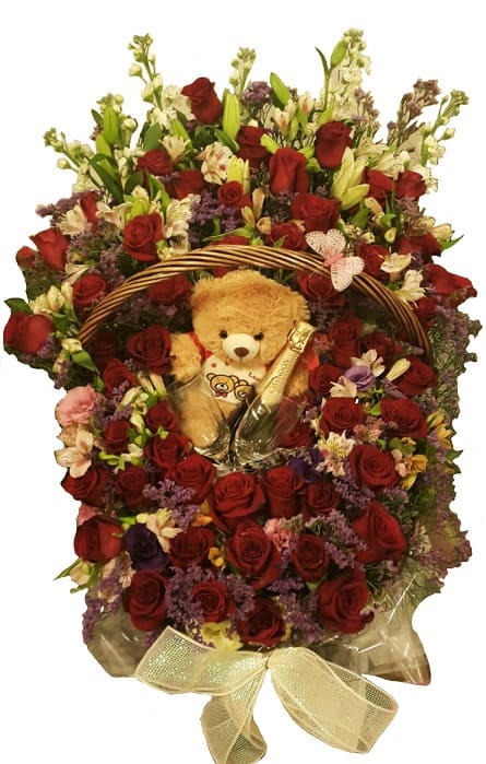 Imagen de Con amor Descripcion: Canasta gigante un metro de 50 rosas y flores variados con un oso chocolate copas y champagne